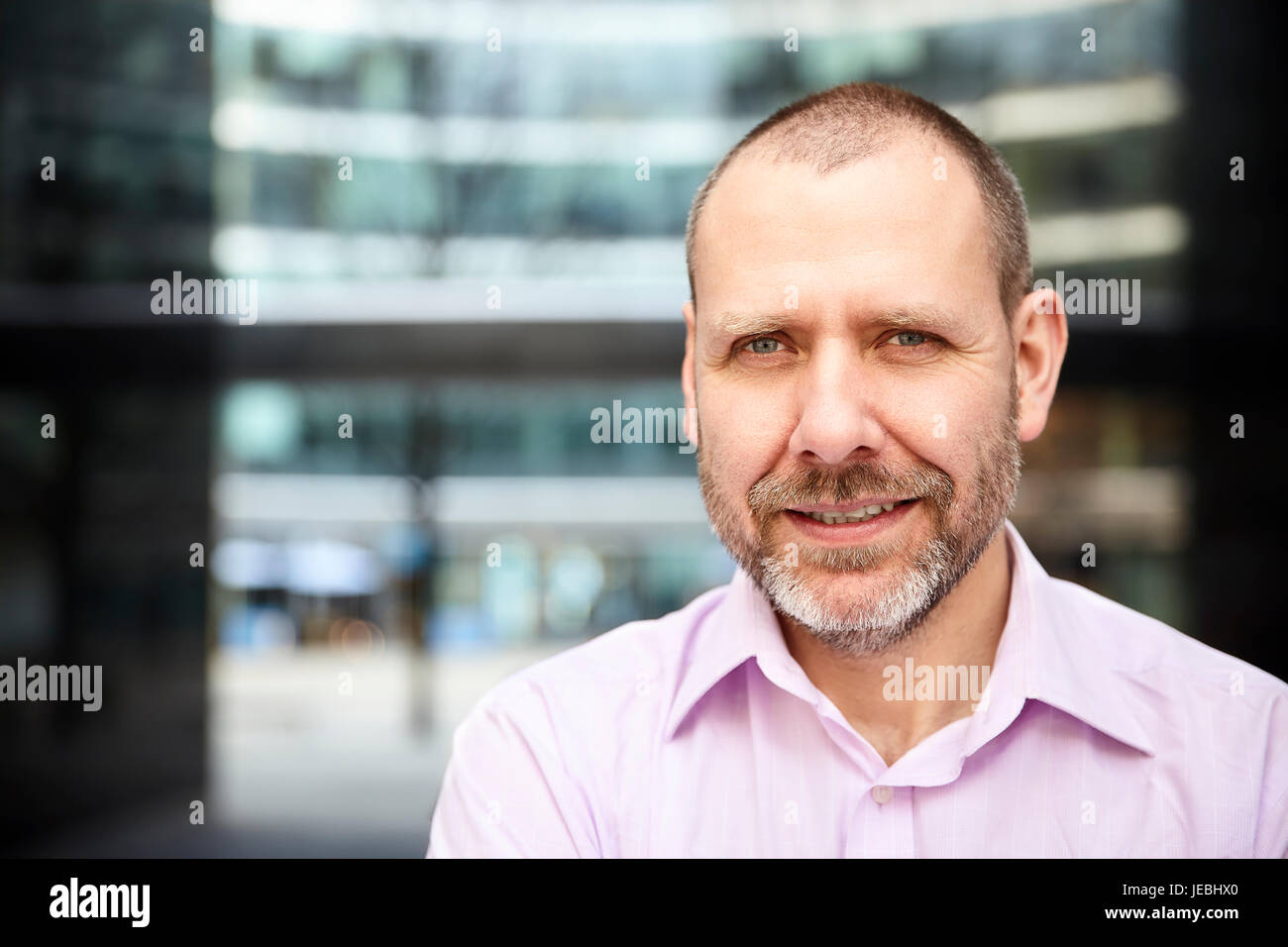 Portrait of pleasant businessman is standing in front of the building Stock Photo Alamy
