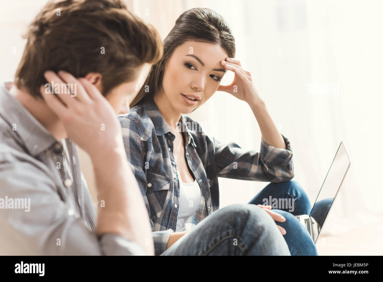 Beautiful couple arguing while sitting on floor at home Stock Photo - Alamy