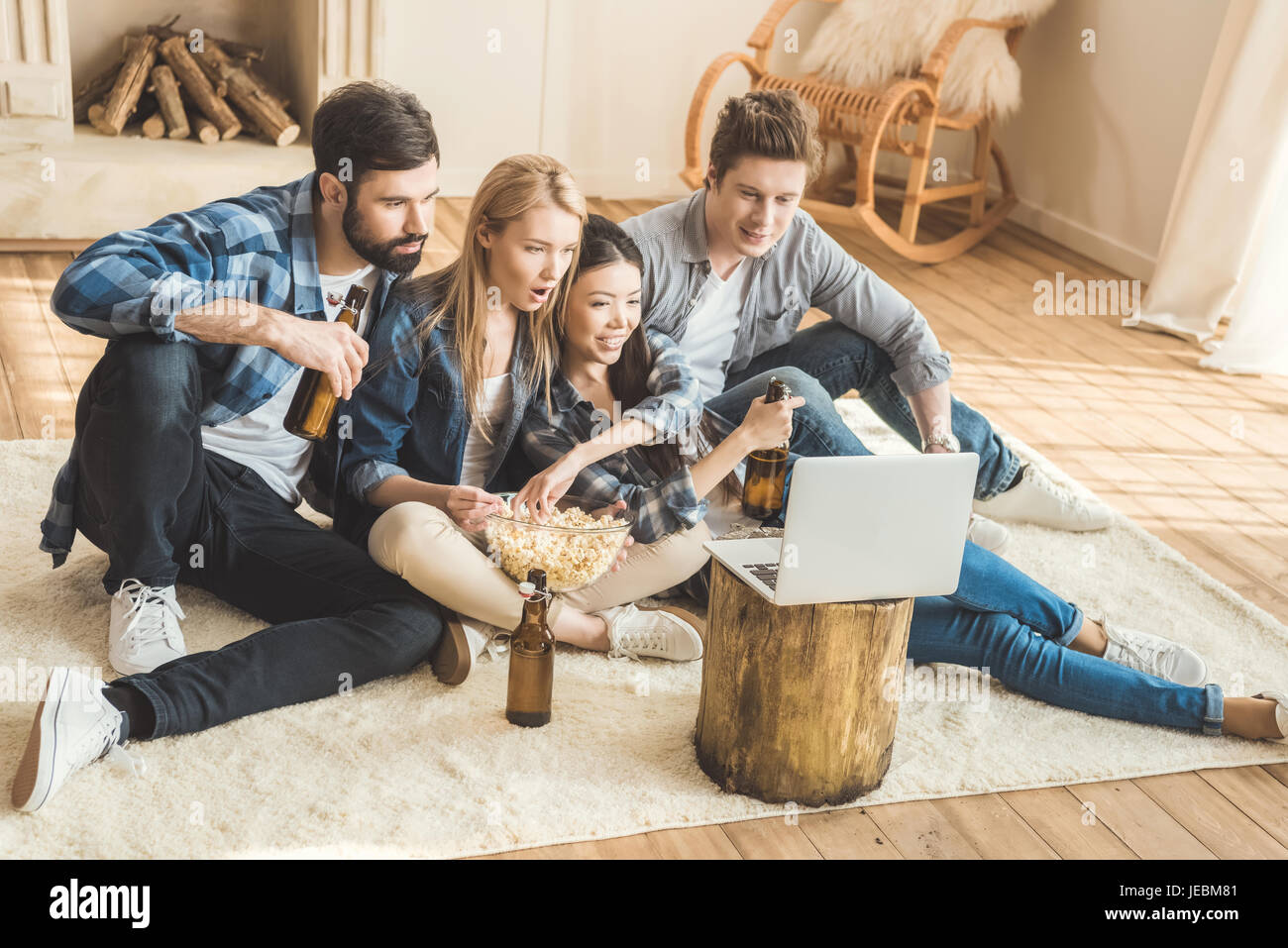 Two young couples watching movie on laptop while drinking beer and