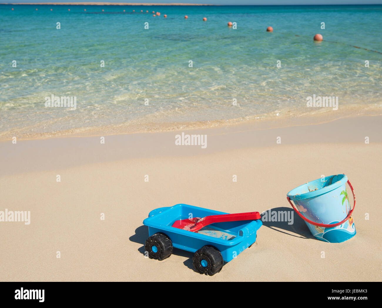 Childrens bucket and spade plastic toys on beach in summer on tropical ocean coast Stock Photo