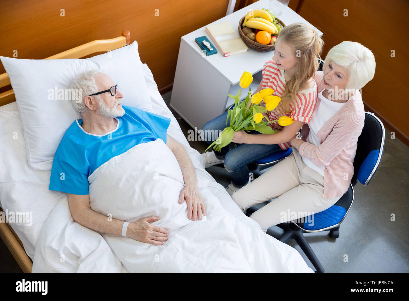 grandmother and granddaughter with tulip flowers visiting patient in