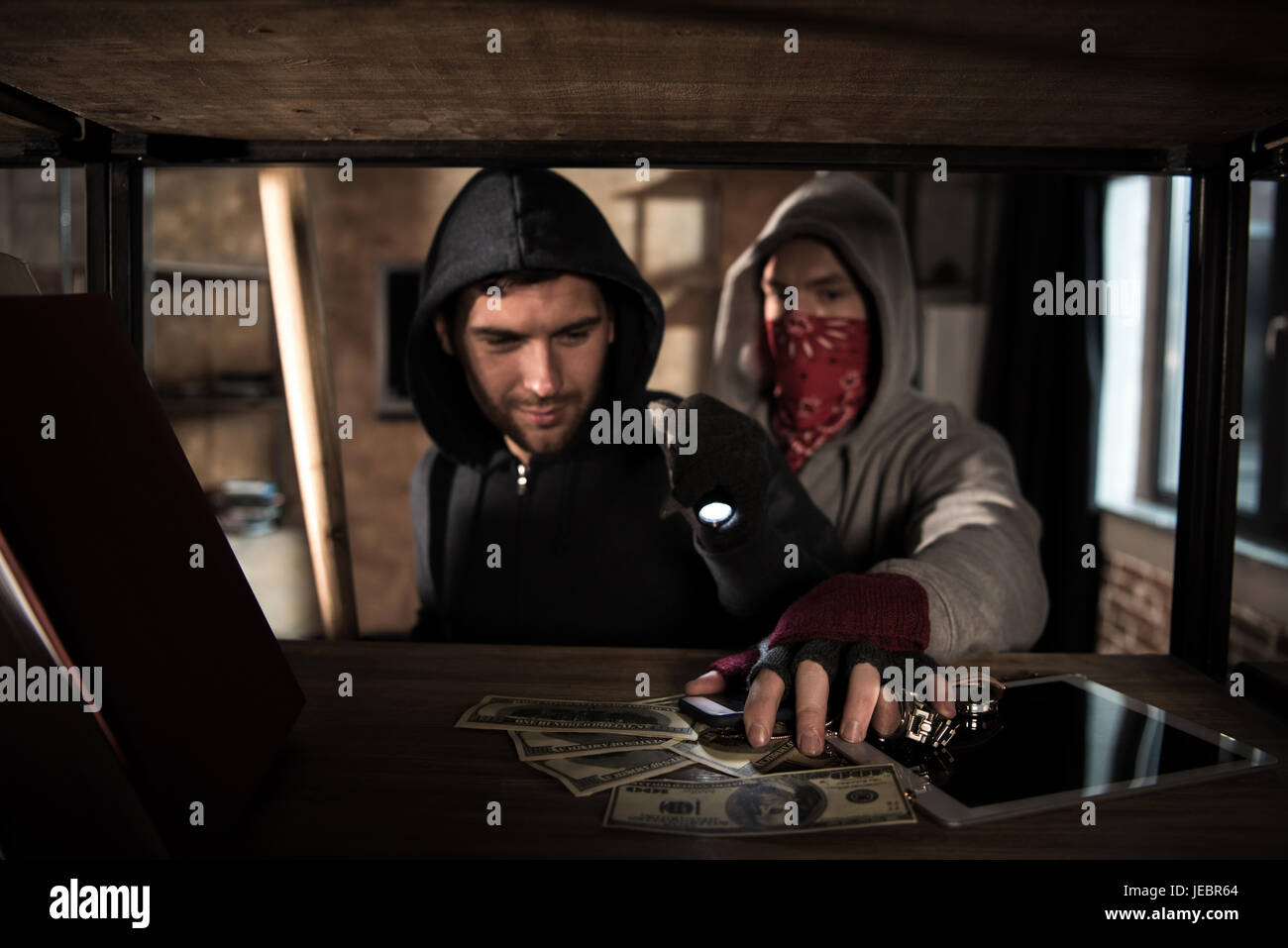 Two robbers stealing money and valuables, house robbery scene Stock