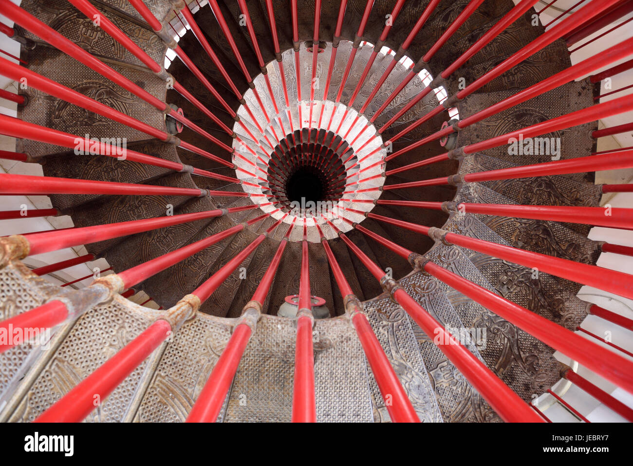 View down the steel double helix spiral staircase at the Ljubljana Castle tower with red bar posts and ornate steps Ljubljana Slovenia Stock Photo