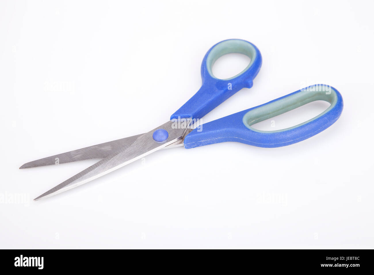 A pair of blue scissors on a white surface. Blue scissors isolated on ...