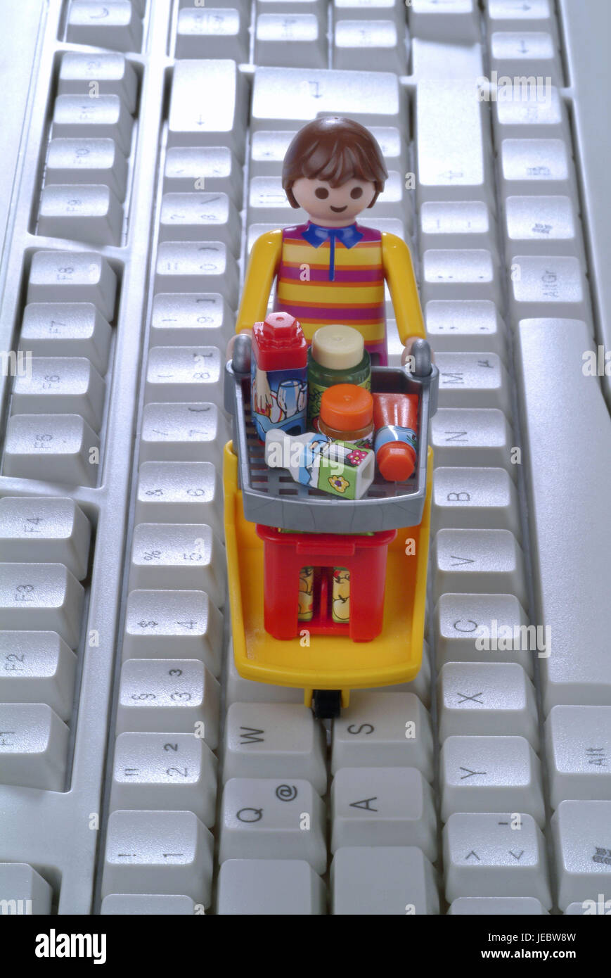 Character by shopping cart on computer keyboard, Stock Photo