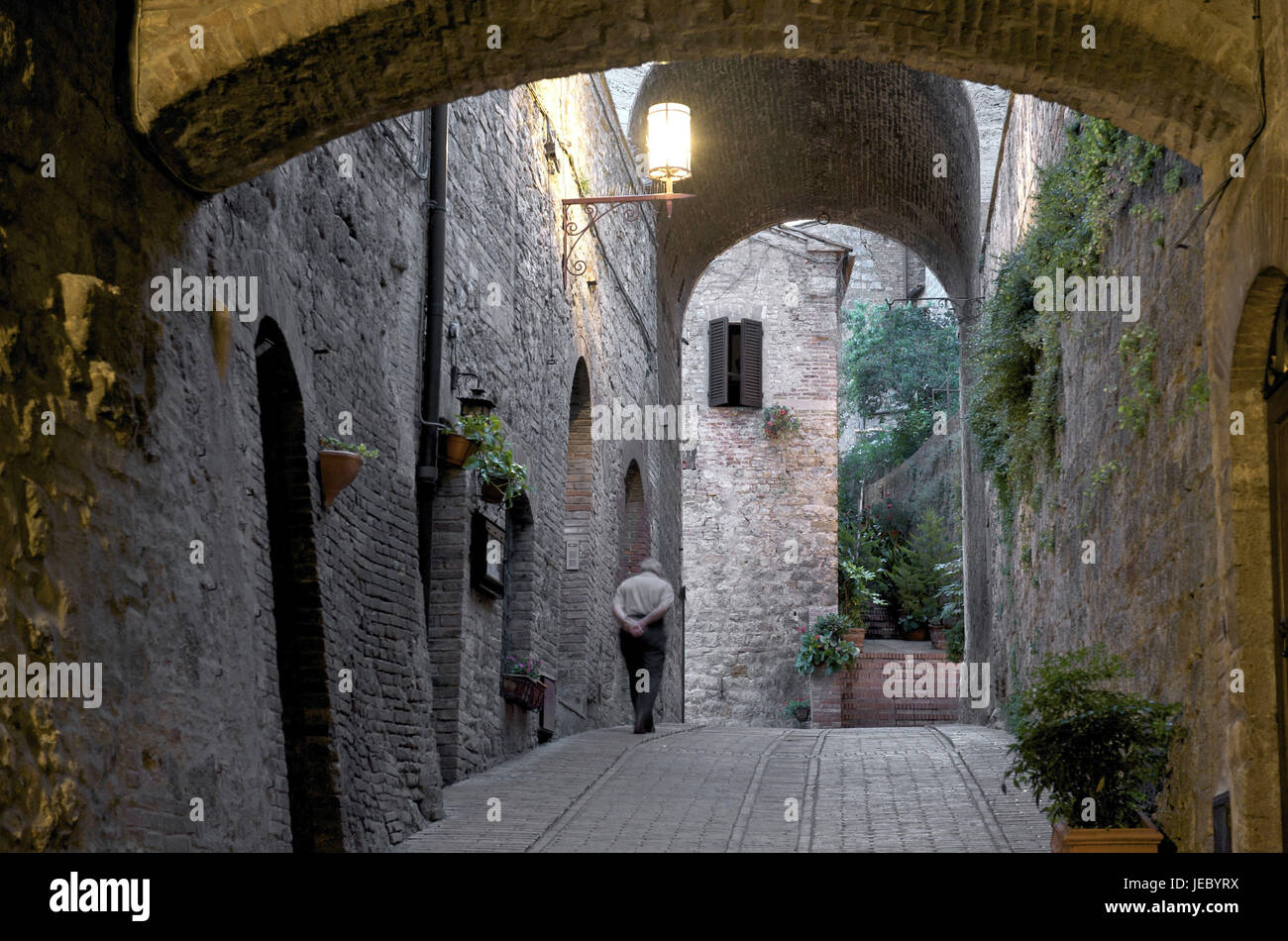 Italy, Tuscany, Val d'Elsa, San Gimignano, man in a lane in the evening, Stock Photo