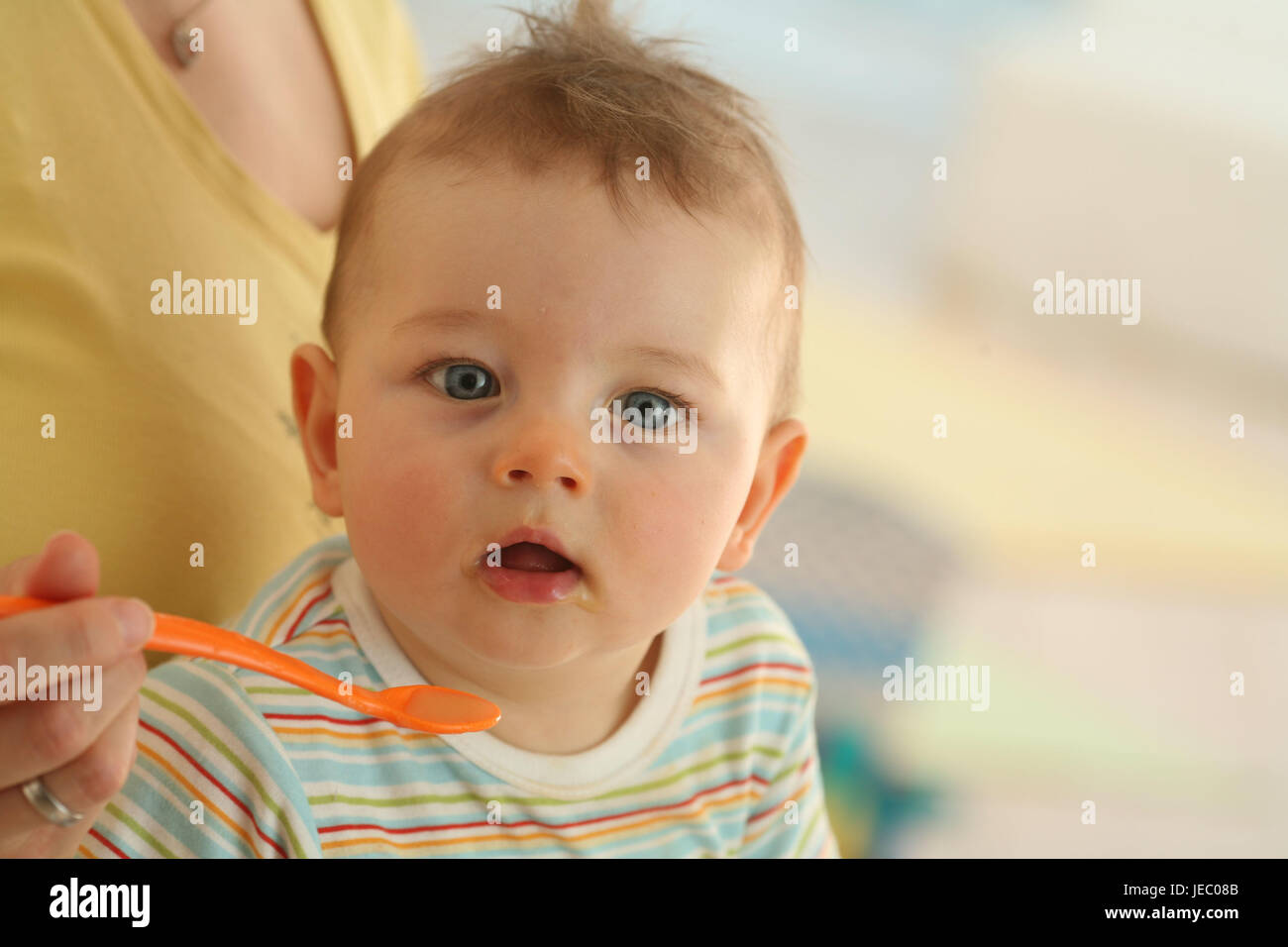 Nut, baby, 7 months, feed, is surprised, dressed, eat, Indoor, boy, curiosity, spoons, hunger, view, portrait, curled, diverted, doubtfully, people, woman, Stock Photo