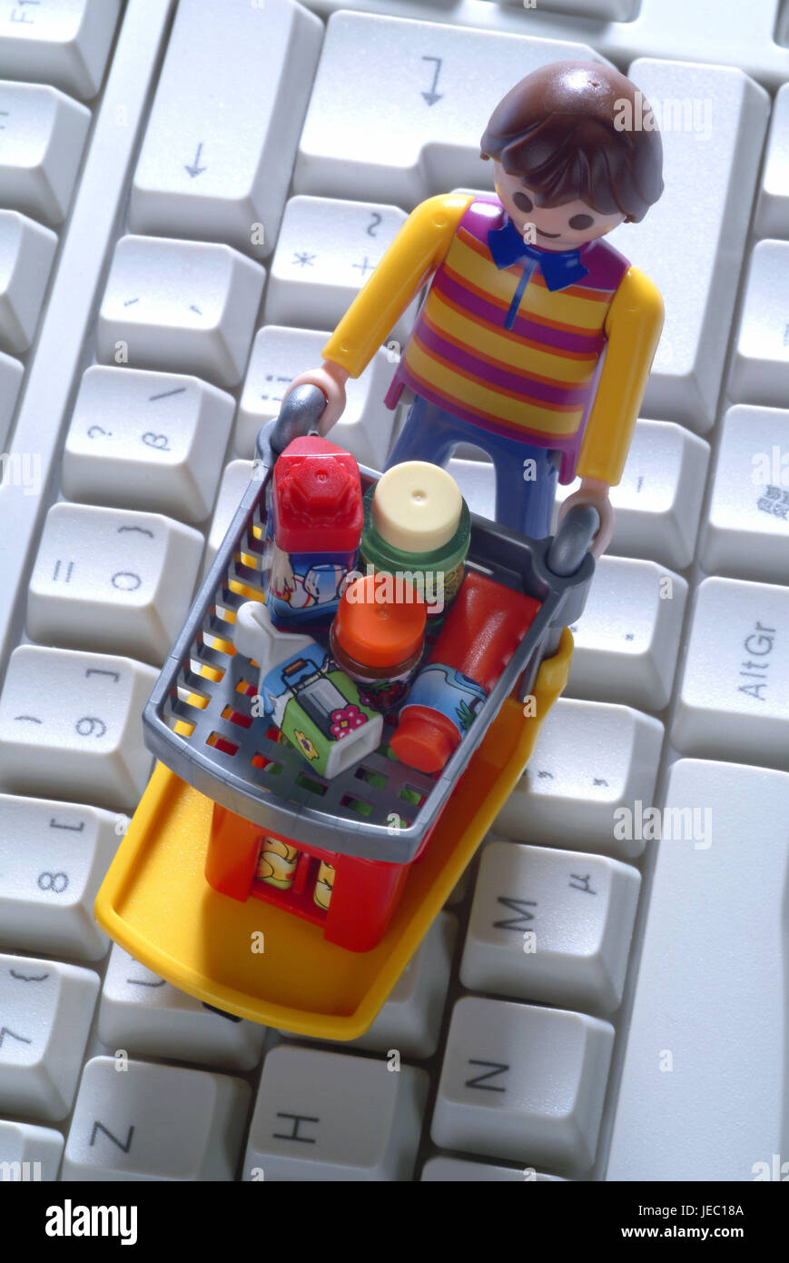 Character by shopping cart on computer keyboard, Stock Photo