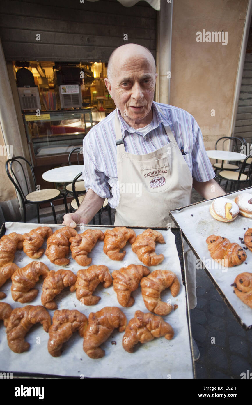 Italy, Rome, baker holds tablets with cake, Stock Photo