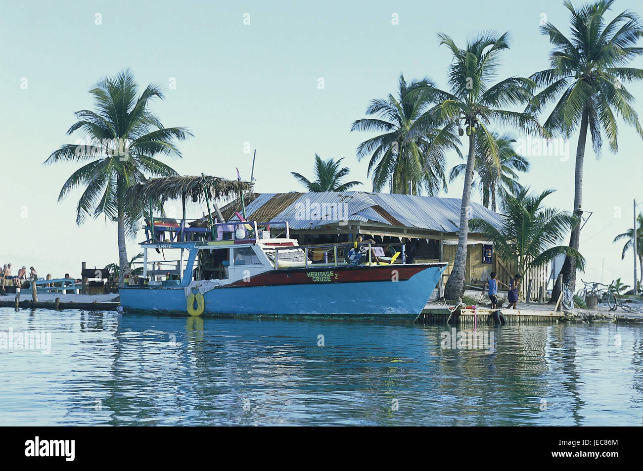 Belize, island Caye Caulker, landing stage, boat, palms, Central America, harbour, fishing boat, excursion boat, tourism, brightly, paints, sea, water, building, corrugated iron, outside, Stock Photo