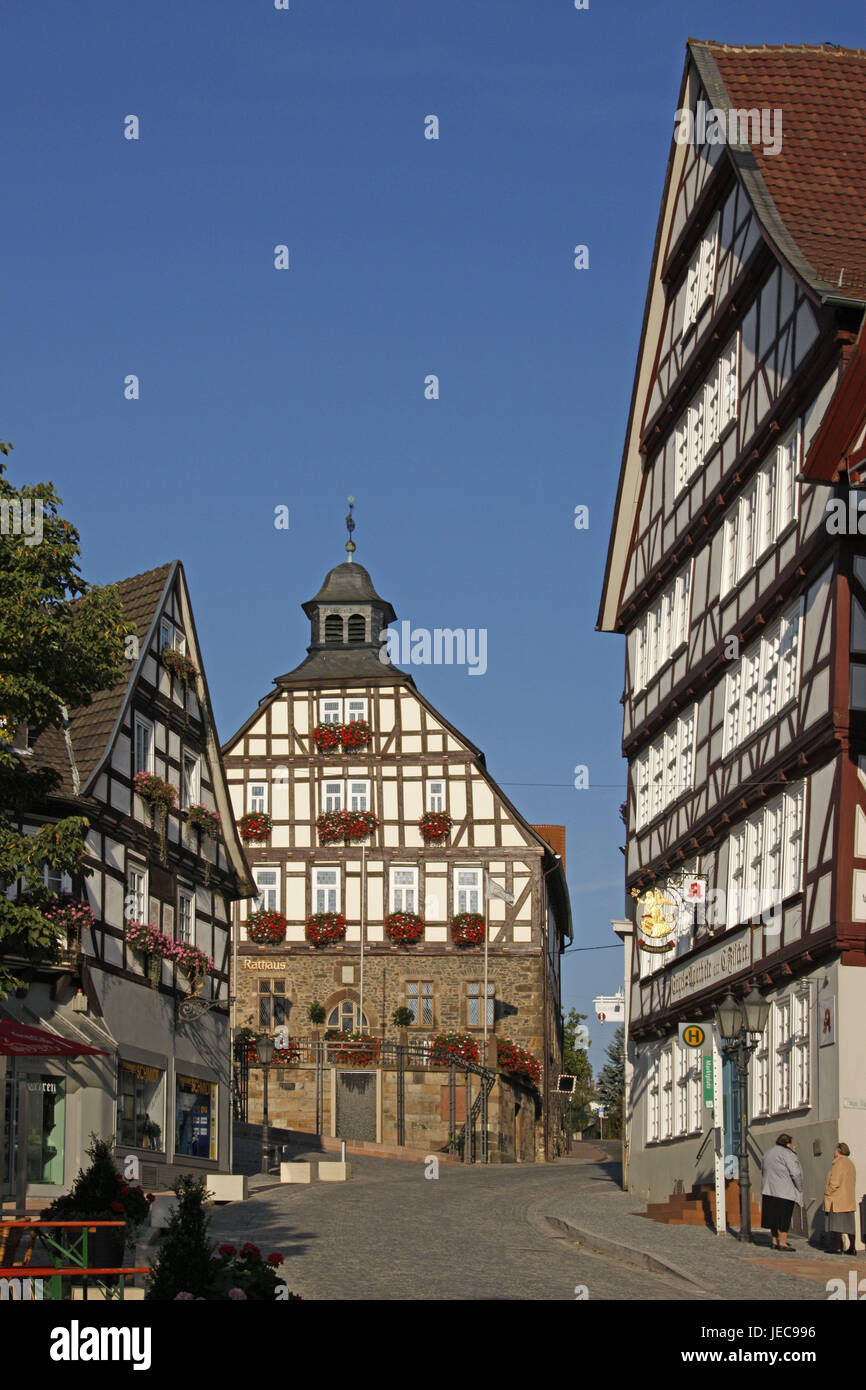 Germany, Hessen, mountain Hom, historical city hall, half-timbered houses, Northern Hessen, town, marketplace, city hall, city hall tower, tower, architecture, architectural style, half-timbered, floral decoration, geraniums, red, street, cobblestones, person, tourism, Stock Photo