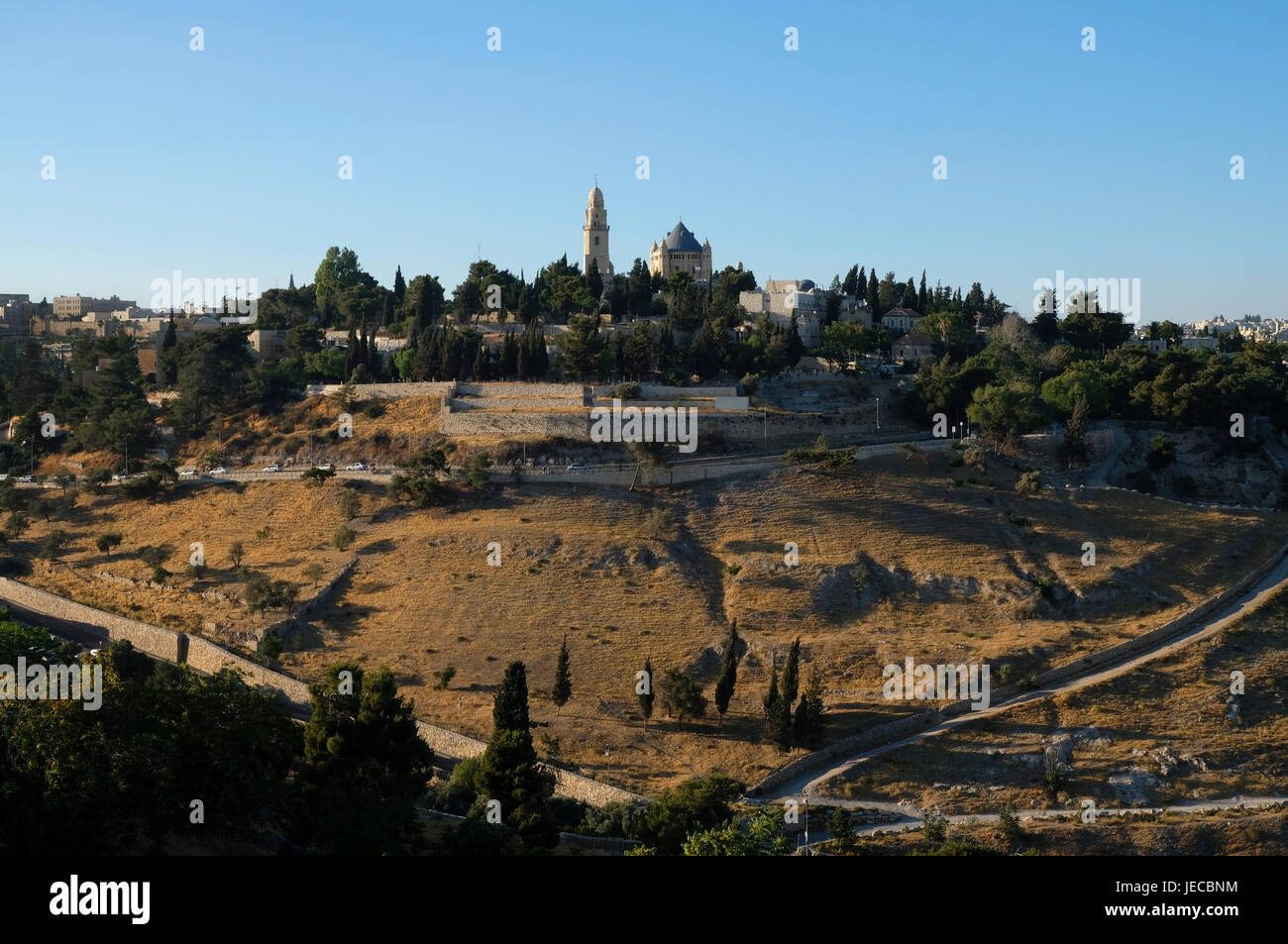 View of Valley of Hinnom the modern name for the biblical Gehenna or Gehinnom valley and the Conical dome and bell tower of the Church of the Dormition or Hagia Maria Sion Abbey on mount Zion in East Jerusalem Israel Stock Photo