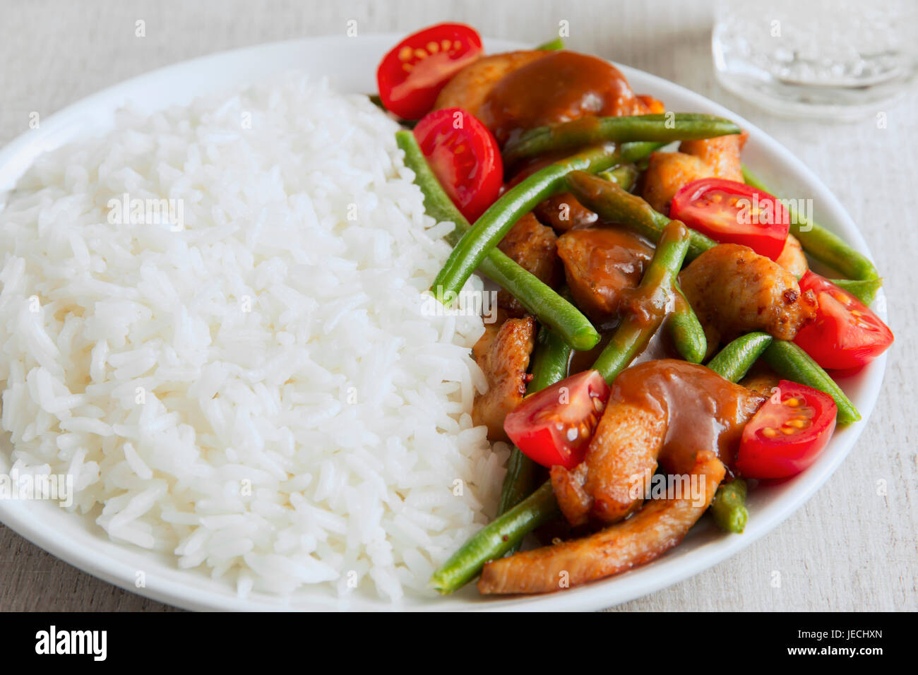 Rice with chicken fillet green beans tomato and sauce Stock Photo