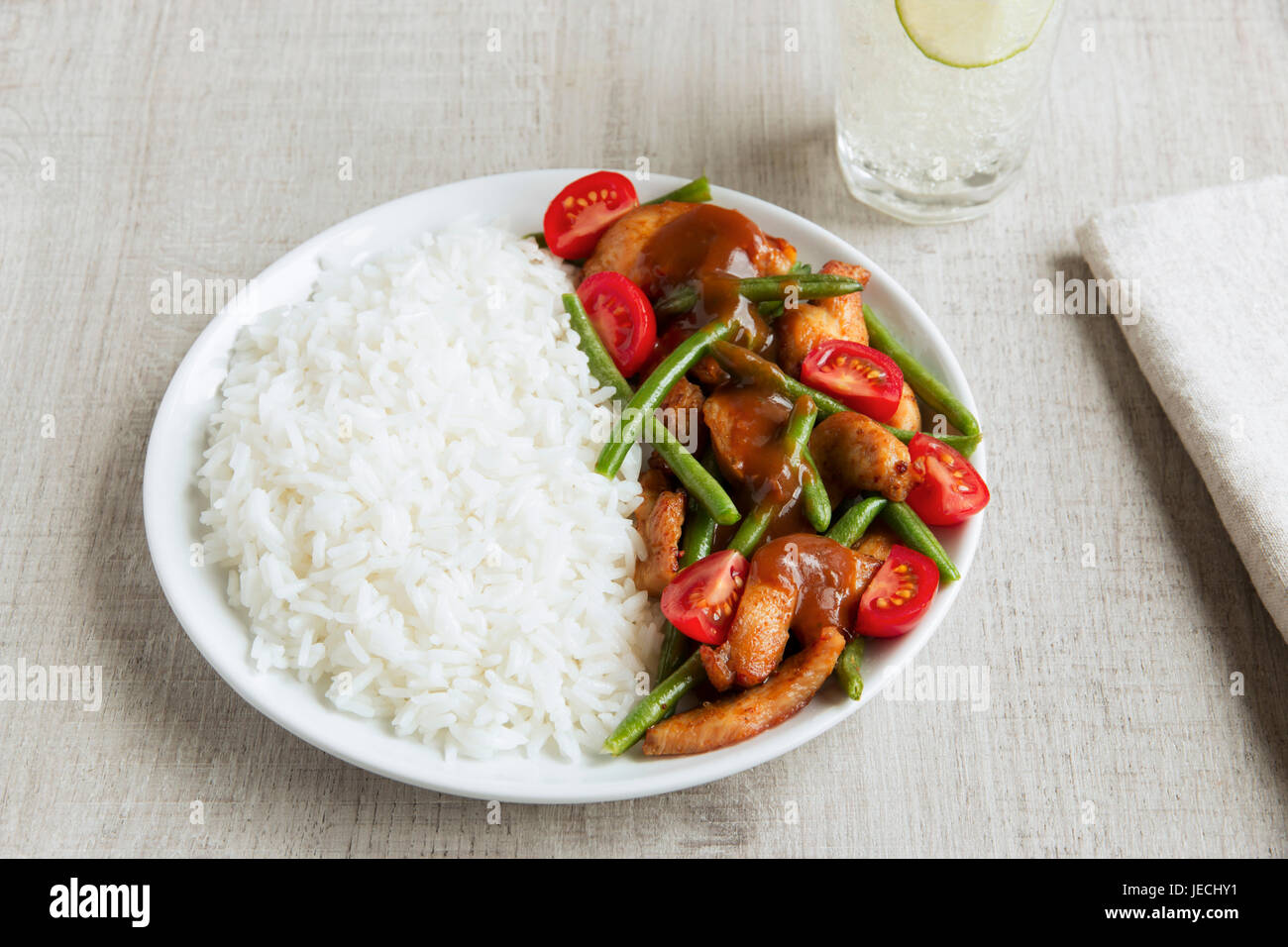 Rice with chicken fillet green beans tomato and sauce Stock Photo
