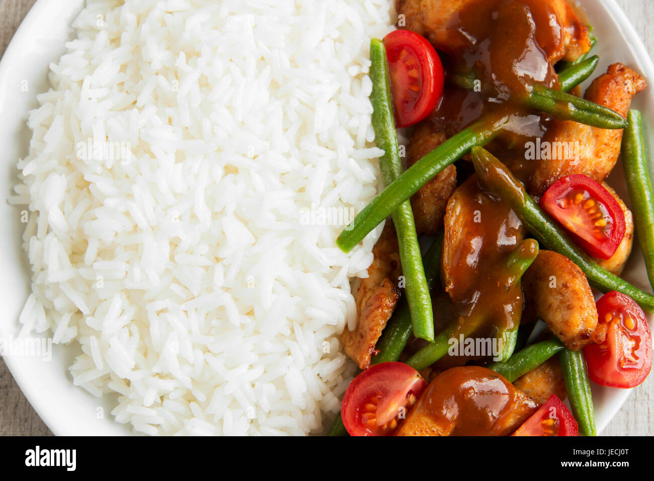 Rice with chicken fillet green beans tomato and sauce Stock Photo Alamy