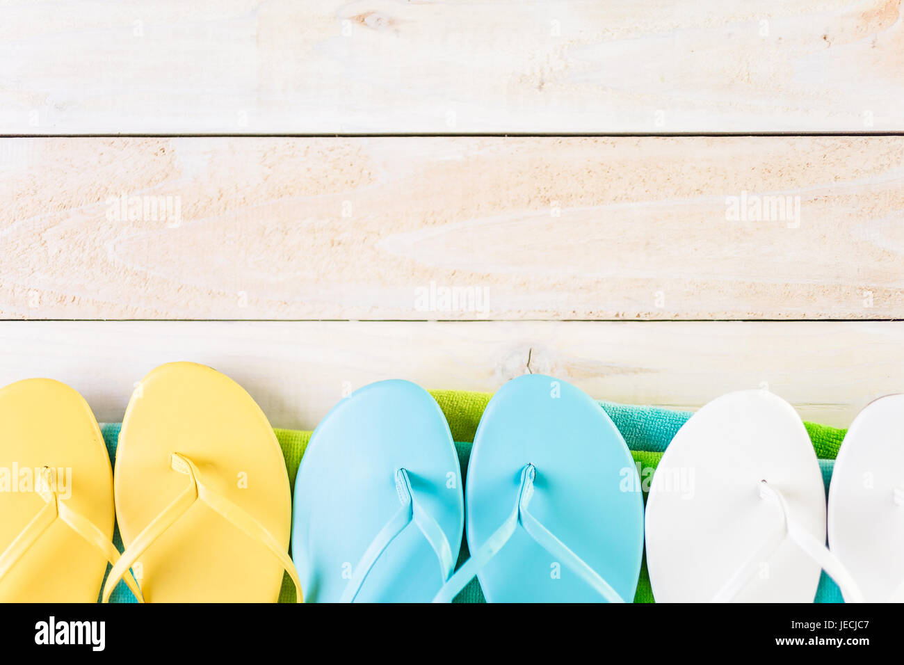 Bright women's flip flops with beach towel Stock Photo - Alamy
