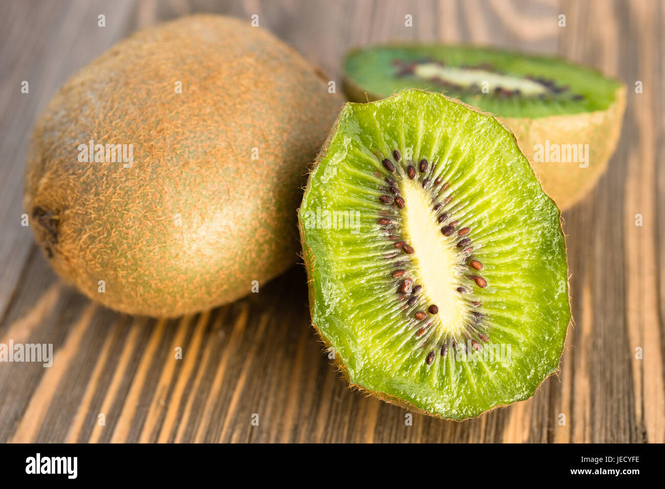 Two Kiwi Fruits sit on the cutting board on cut in half Stock Photo Alamy