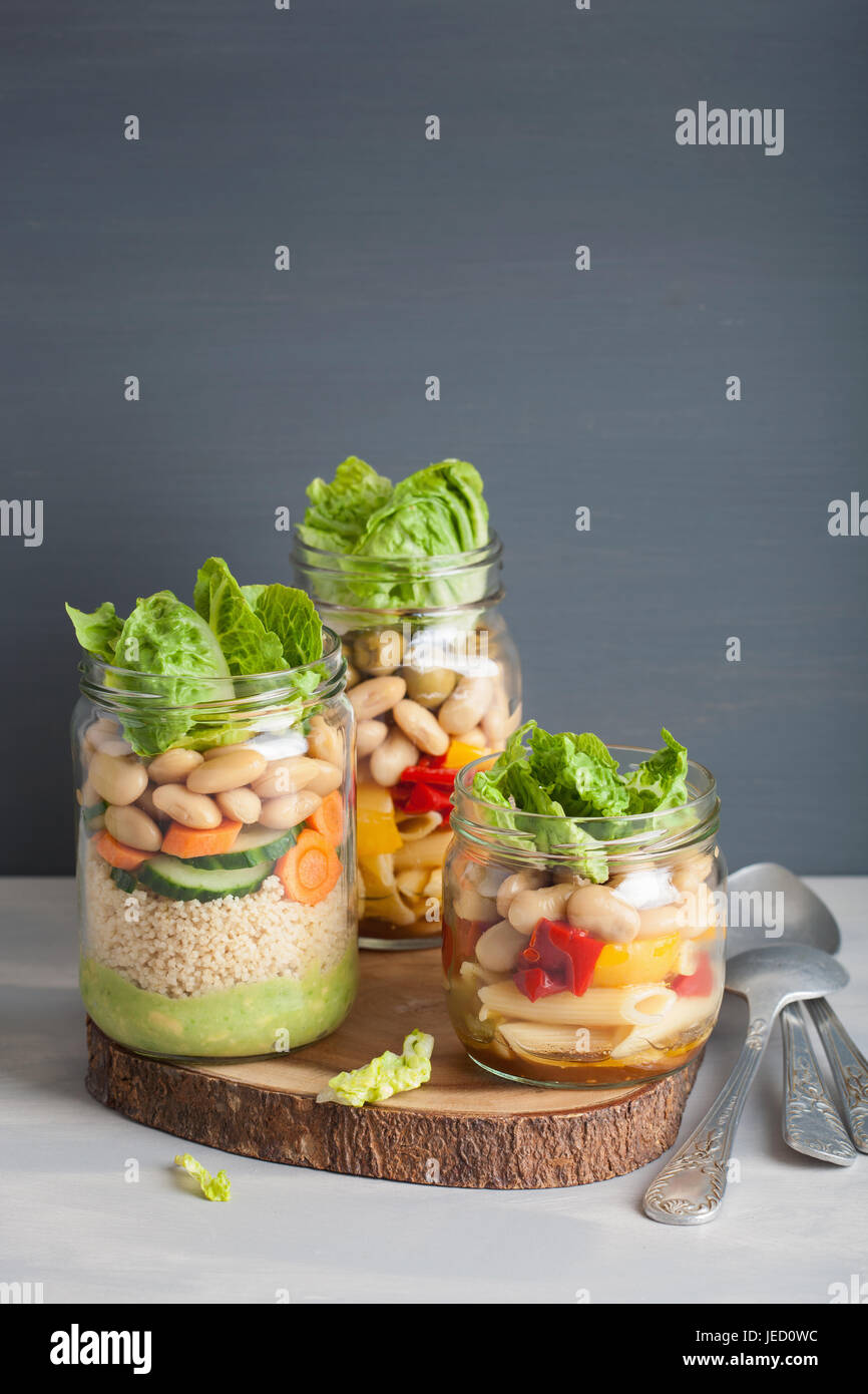 vegan couscous and pasta salad in mason jars with vegetables beans