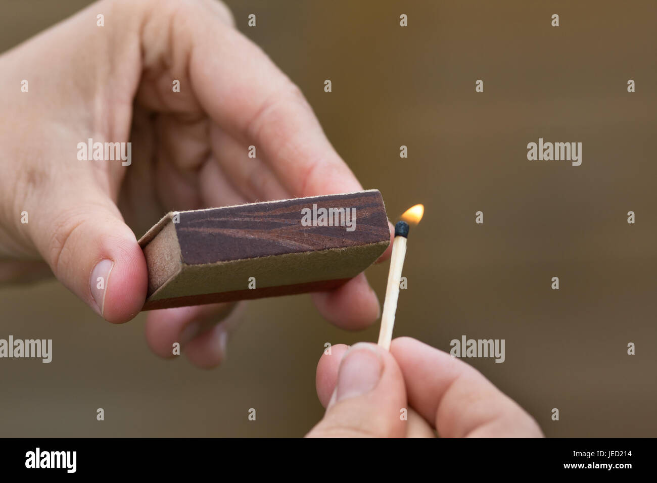hands striking a match on blurred background Stock Photo Alamy