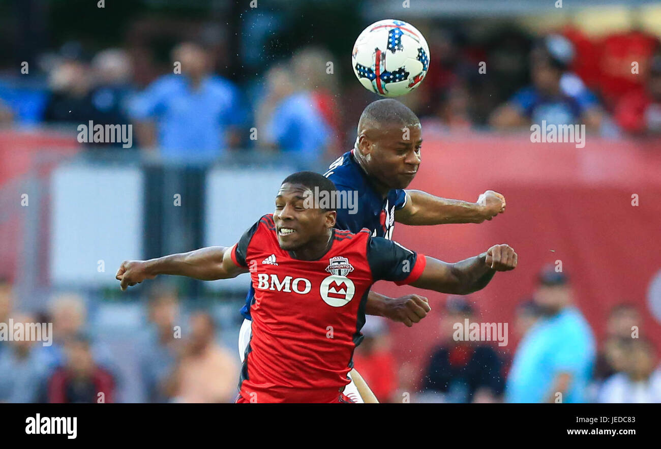 Toronto, Canada. 23rd June, 2017. Armando Cooper (L) of Toronto FC vies with Andrew Farrell of New England Revolution during the 2017 Major League Soccer (MLS) match between Toronto FC and New England Revolution at BMO Field in Toronto, Canada, on June 23, 2017. Toronto FC won 2-0. Credit: Zou Zheng/Xinhua/Alamy Live News Stock Photo