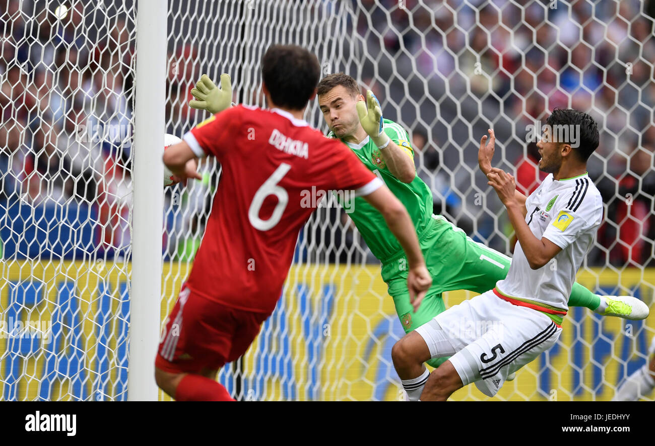 Kazan, Russia. 24th June, 2017. Russian goalkeeper Igor Akinfeev (C) is unable to stop the shot by Mexico's Nestor Araujo (not pictured) for the 1:1 equalizer during the group stage match pitting Mexico against Russia at the Kazan Arena in Kazan, Russia, 24 June 2017. On the left side Russia's Georgi Dzhikiya looks on, while Mexico's Diego Reyes can be seen on the right side. Photo: Marius Becker/dpa/Alamy Live News Stock Photo