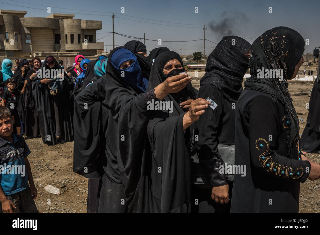 Civilians line up for an aid distribution in the al-Mansur neighbourhood in western Mosul, Iraq, 24 June 2017. Photo: Andrea DiCenzo/dpa Stock Photo