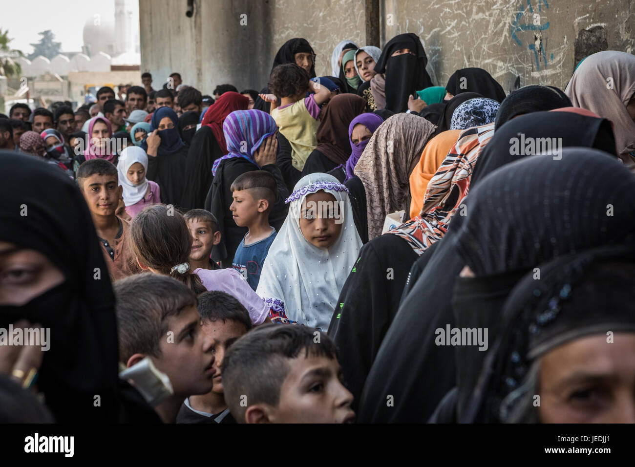 Civilians line up for an aid distribution in the al-Mansur neighbourhood in western Mosul, Iraq, 24 June 2017. Photo: Andrea DiCenzo/dpa Stock Photo