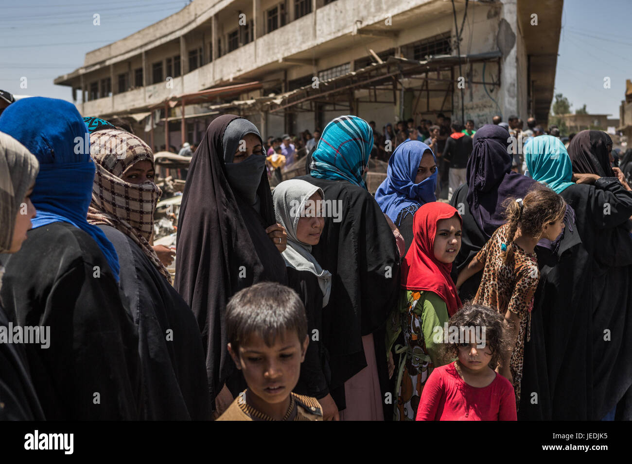 Civilians line up for an aid distribution in the al-Mansur neighbourhood in western Mosul, Iraq, 24 June 2017. Photo: Andrea DiCenzo/dpa Stock Photo