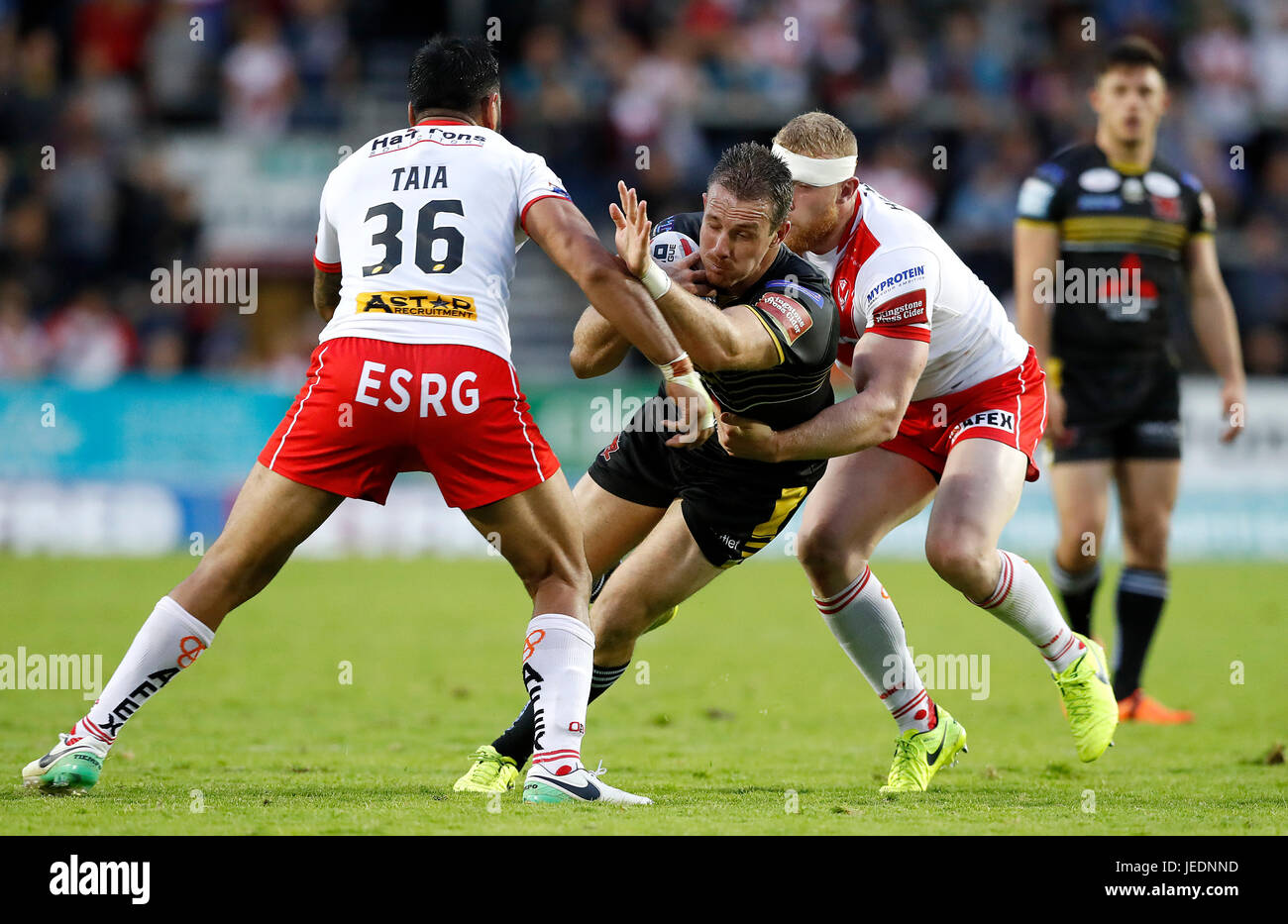 Salford Red Devils' James Hasson is tackled by St Helens Zeb Taia (left) and Luke Thompson (right), during the Betfred Super League match at the AJ Bell Stadium, Salford. Stock Photo