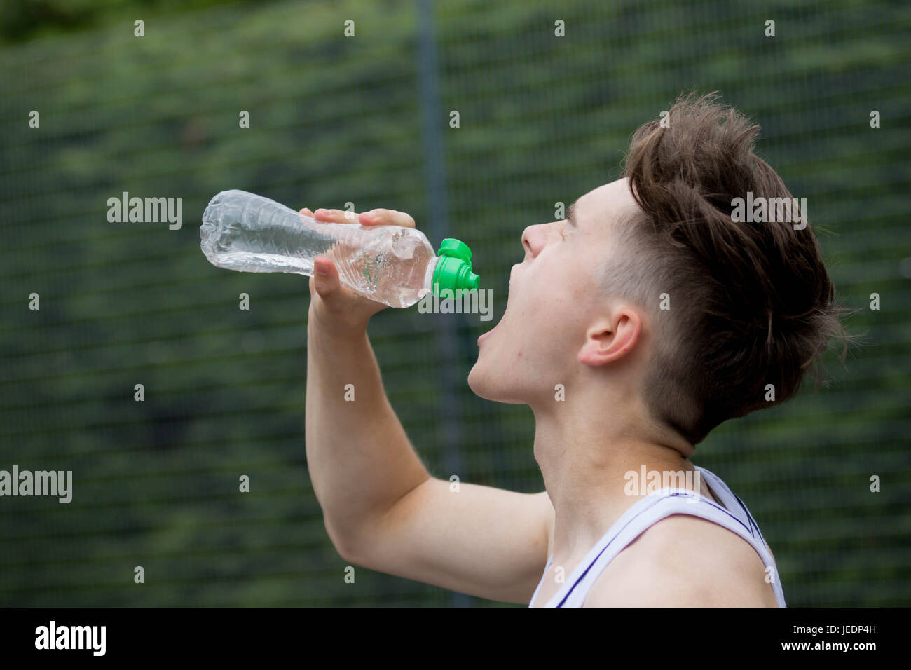 Boy Drinking From Water Bottle Side View High-Res Stock Photo