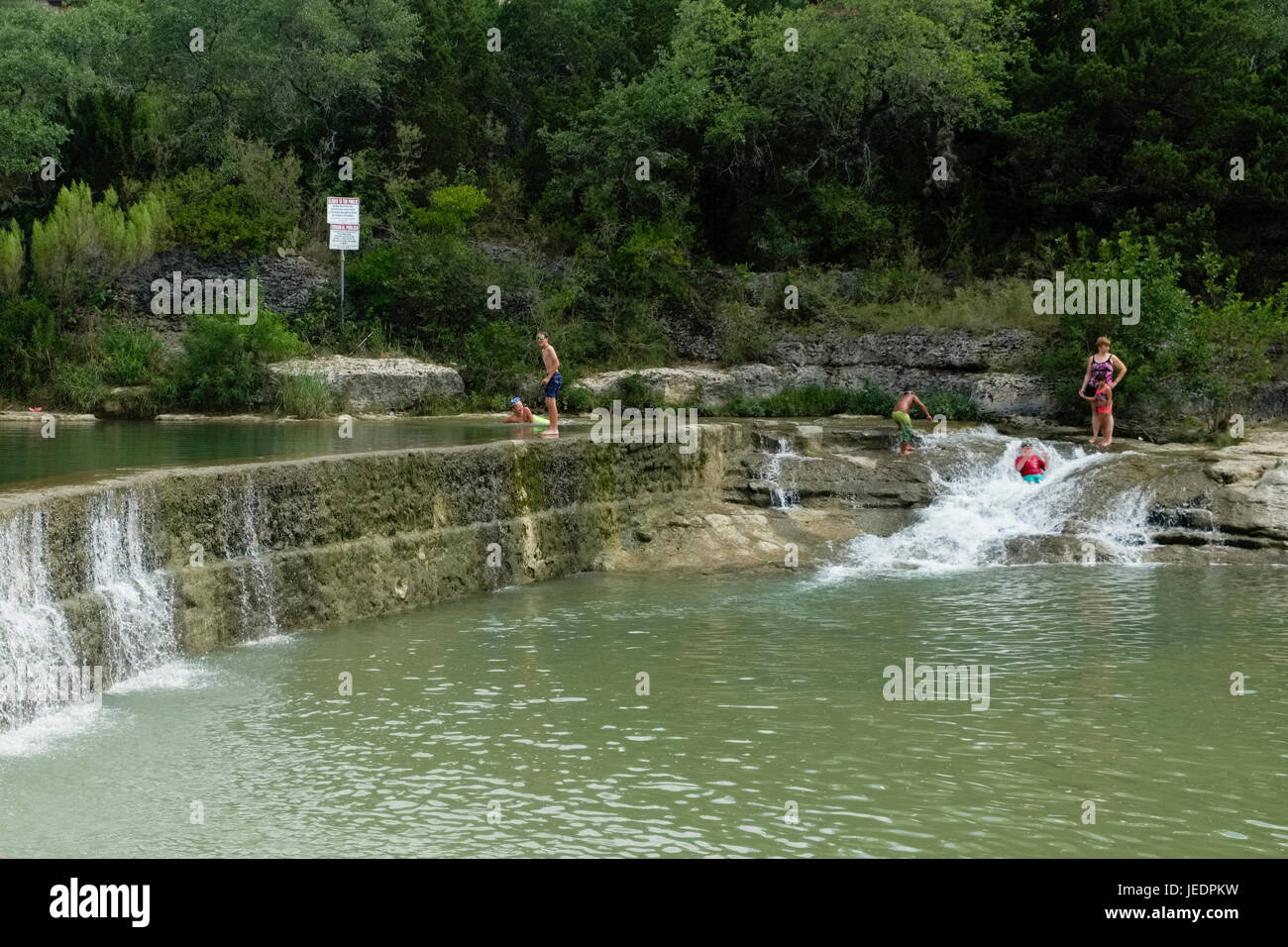 Swimming in a local community swimming hole known as Blue Hole on the San Gabriel River in Georgetown, Texas USA Stock Photo
