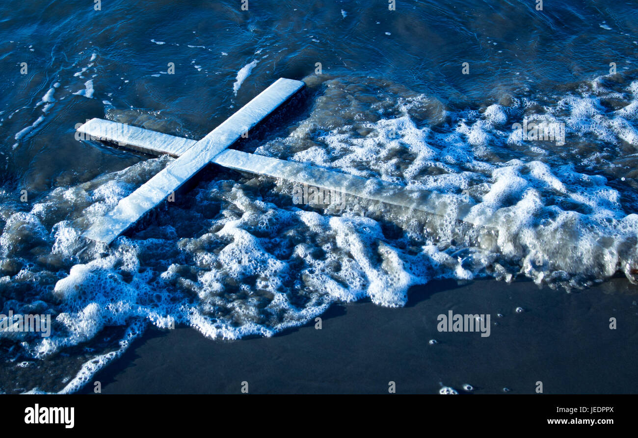 White cross that has been wash up on a beach. Stock Photo