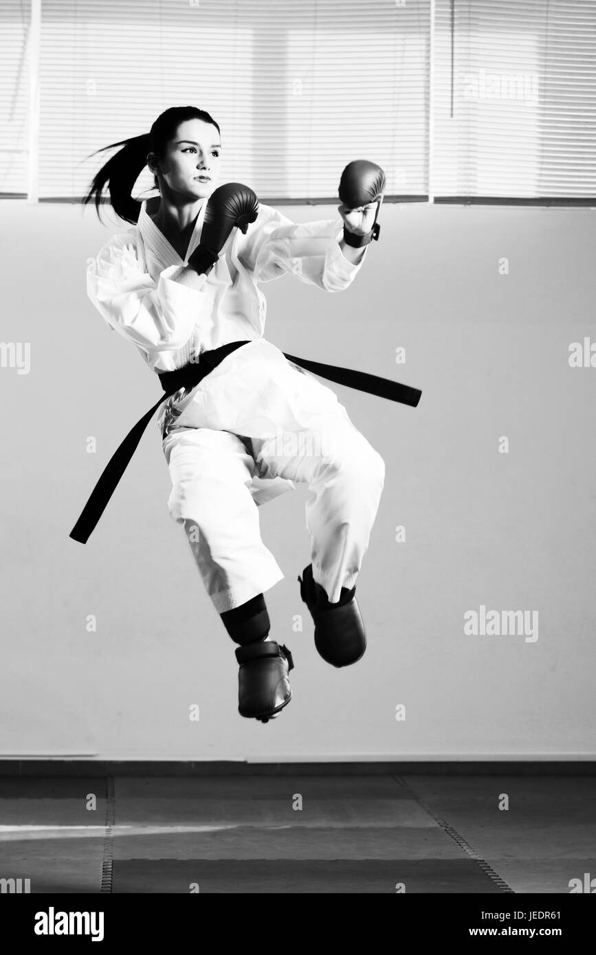 Young Woman Practicing Her Karate Moves - White Kimono - Black Belt Stock Photo