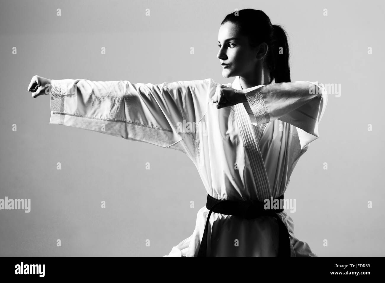 Young Woman Dressed In Traditional Kimono Practicing Her Karate Moves - Black Belt Stock Photo