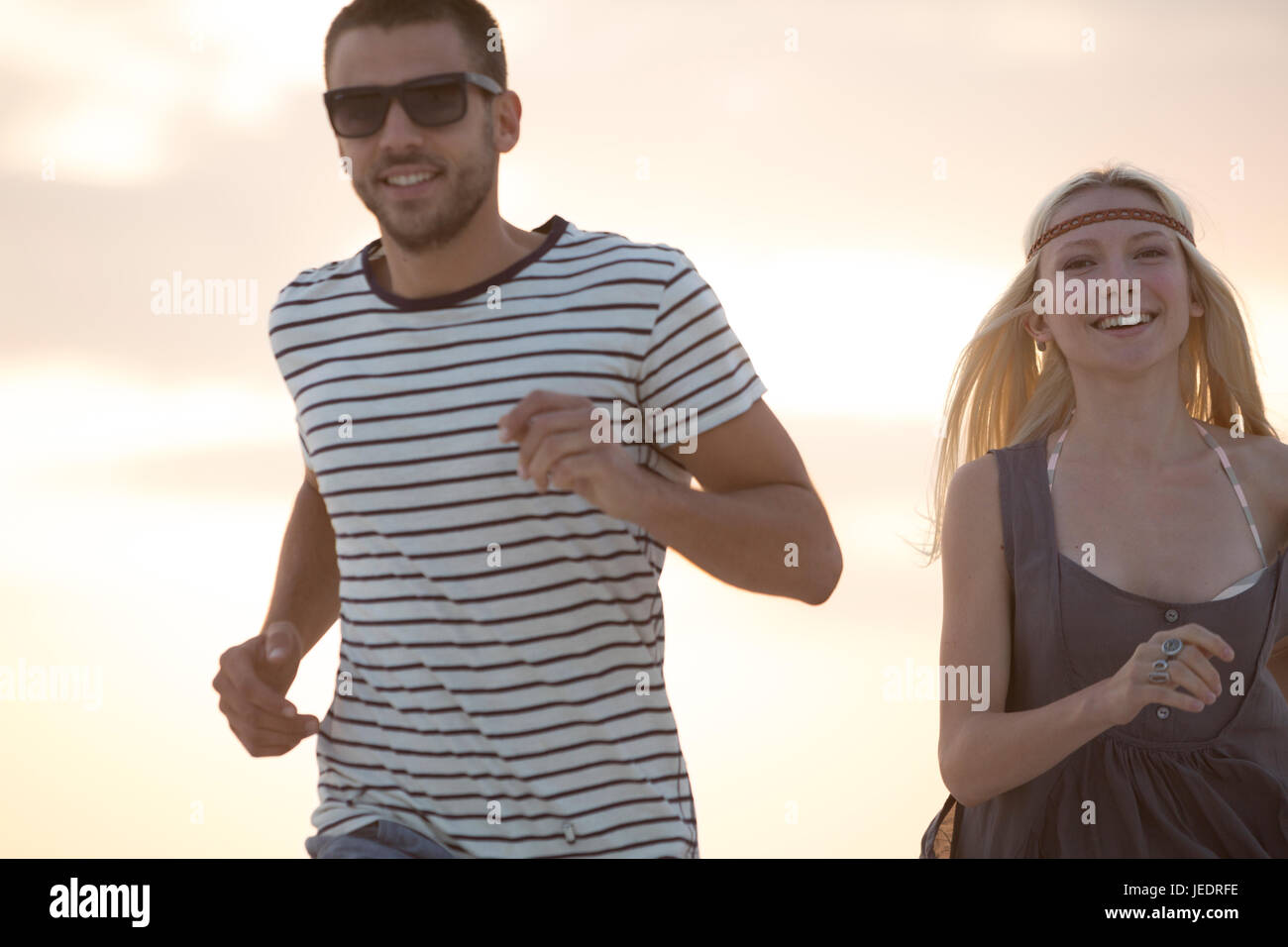 Young couple running on the beach Stock Photo - Alamy