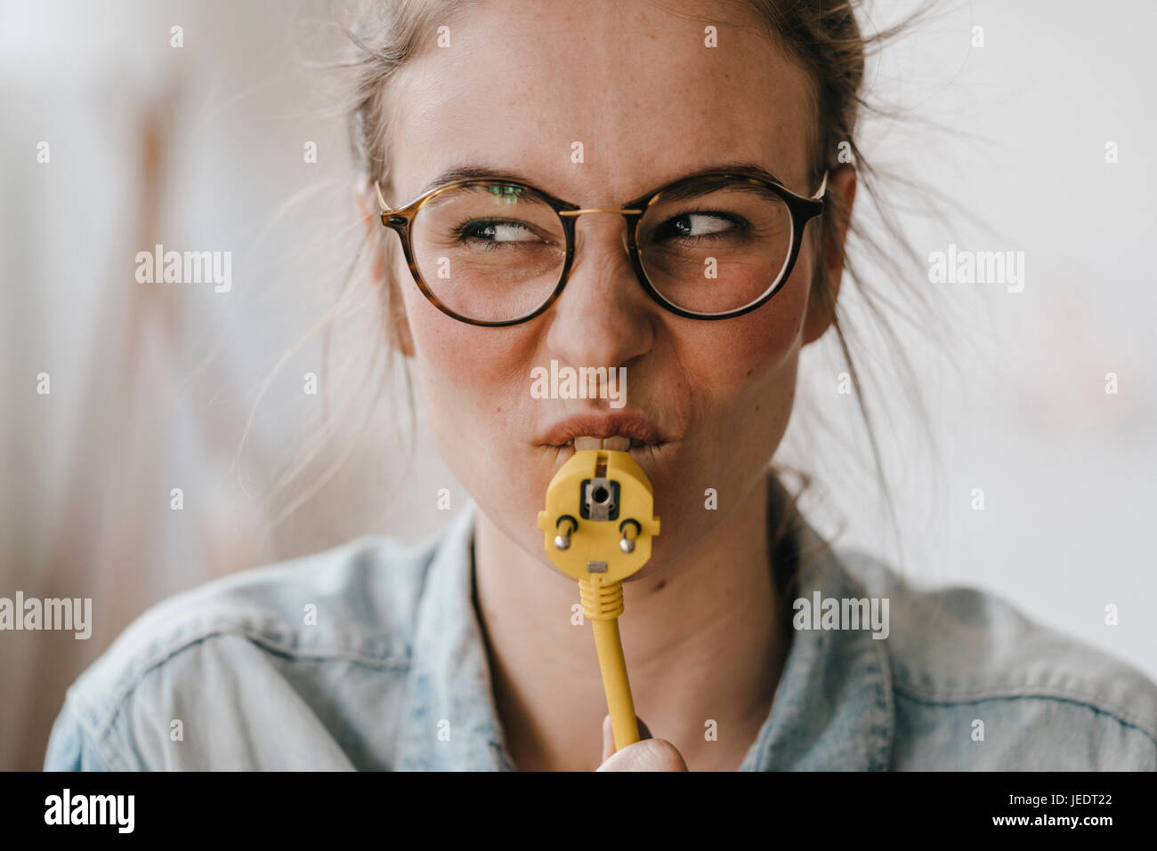Playful young woman with power cable Stock Photo Alamy