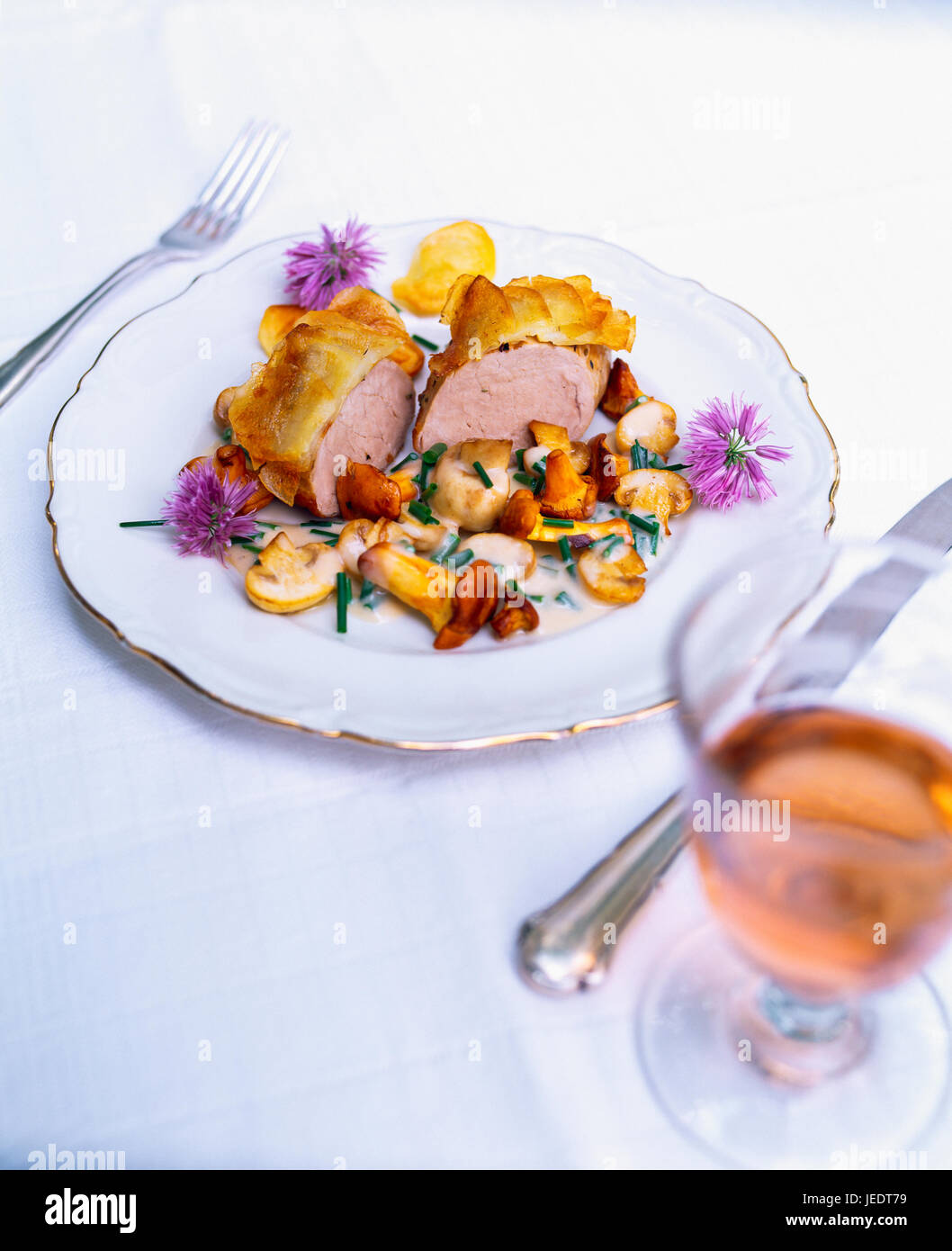 Schweinefilet mit Kartoffelkruste, Pilzen und Schnittlauchblüten Stock  Photo - Alamy