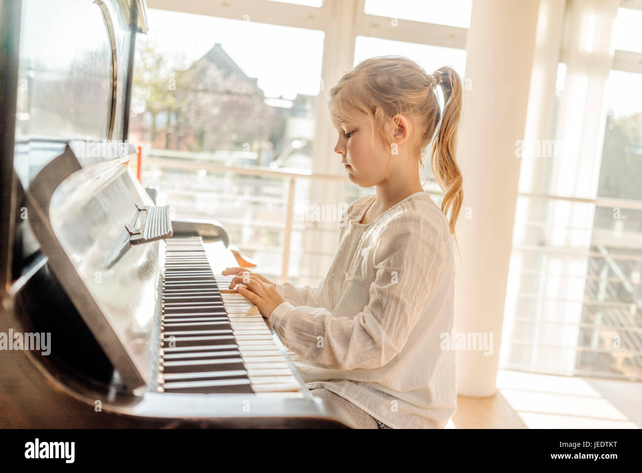 Girl at home playing piano Stock Photo