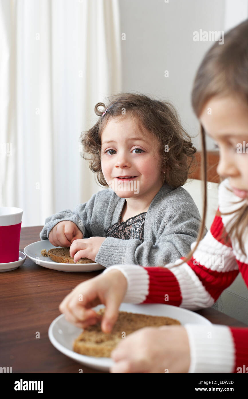 Portrait of smiling little girl at breakfast table Stock Photo - Alamy
