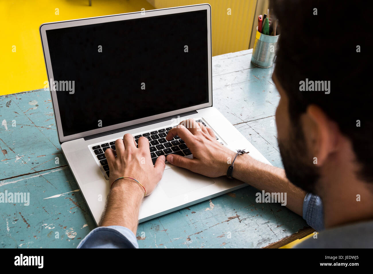 Man sitting at desk working with his laptop Stock Photo