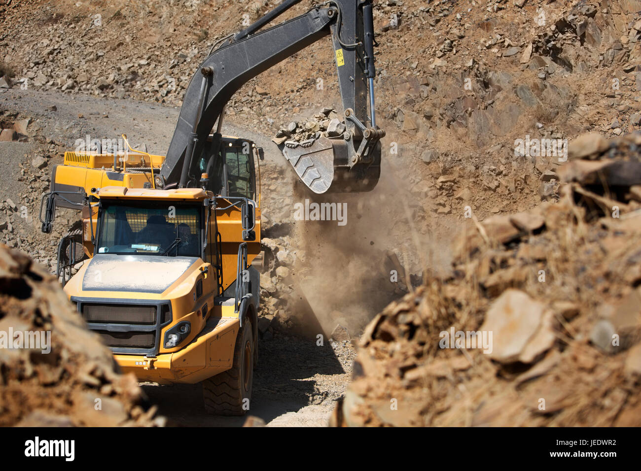 Digger working in quarry Stock Photo - Alamy