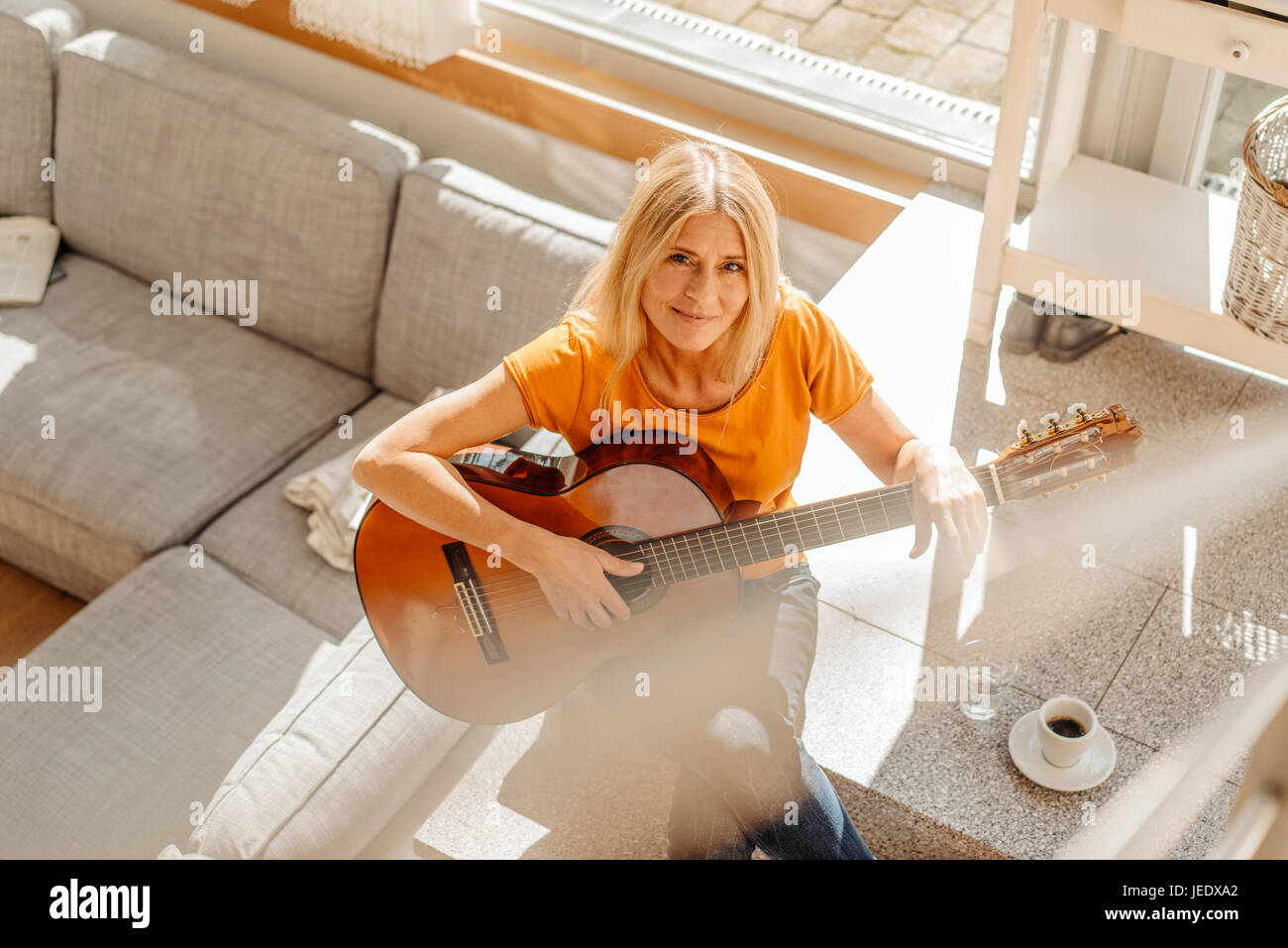 Woman at home playing guitar Stock Photo
