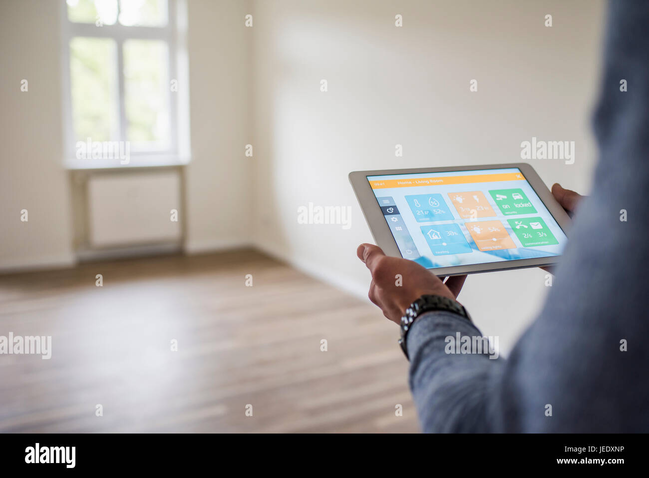Man in new home using tablet with smart home apps Stock Photo