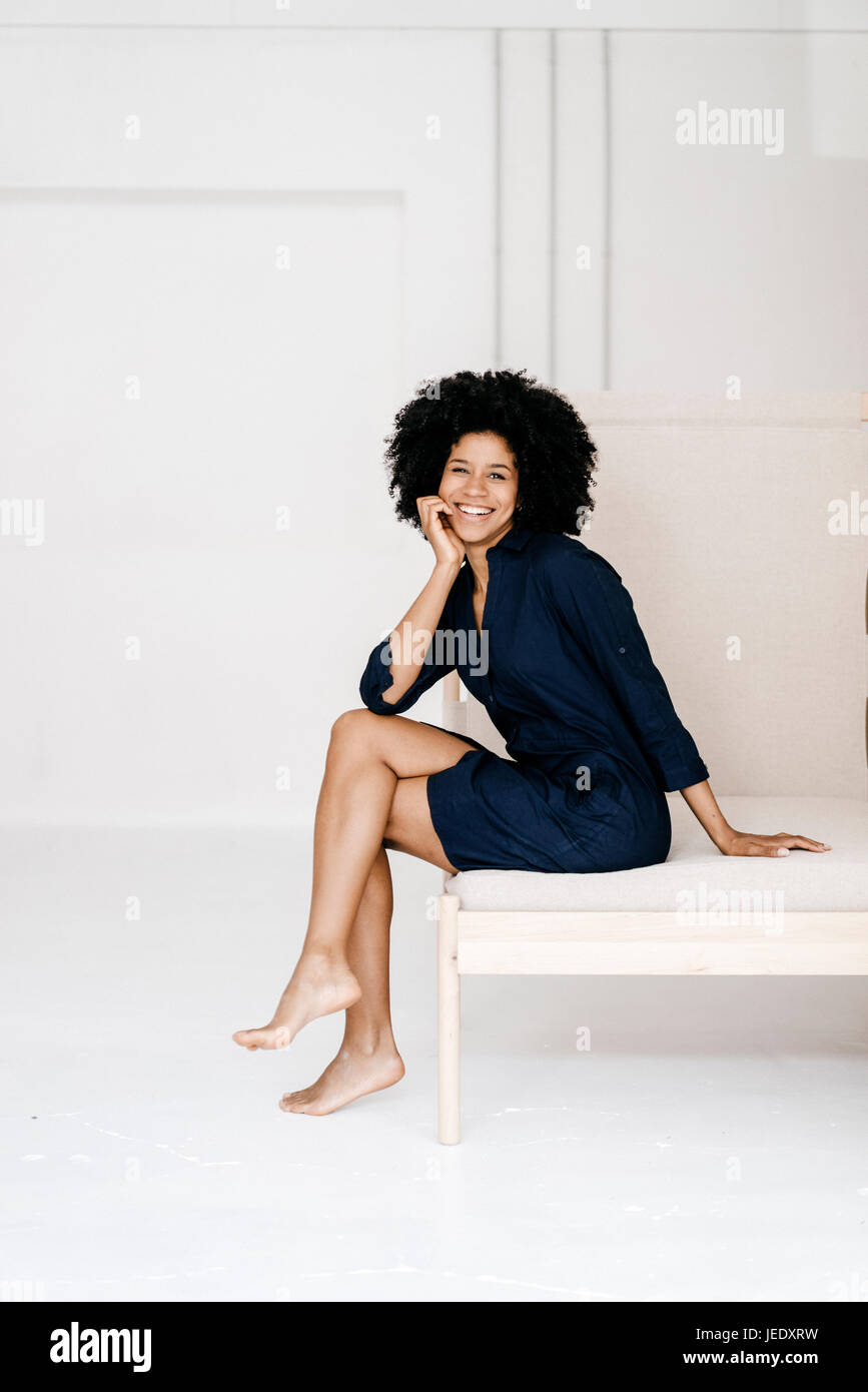 Pretty young woman sitting on bed Stock Photo - Alamy