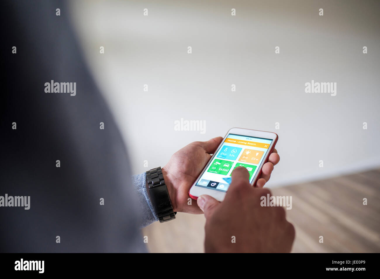 Man at home using smartphone with smart home apps Stock Photo