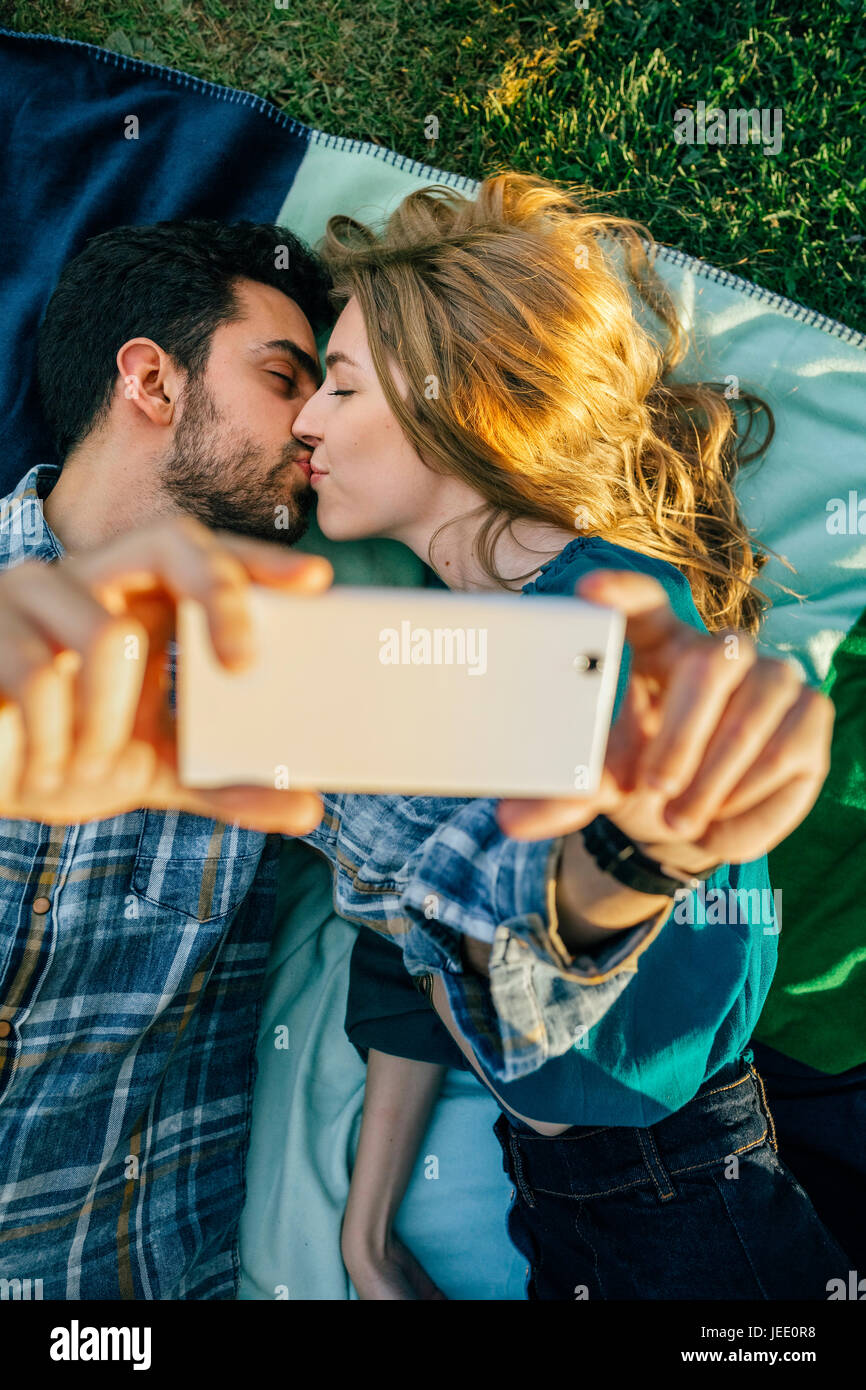 Couple in love taking selfie with smartphone while kissing Stock Photo ...