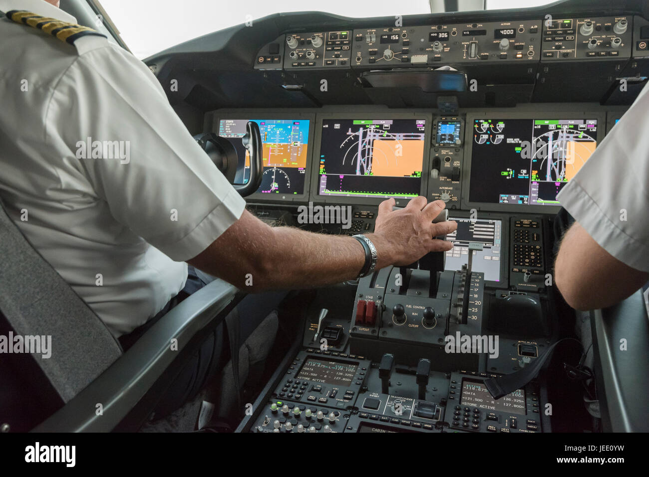 Flight deck of a modern commercial jet aircraft with two pilots at the