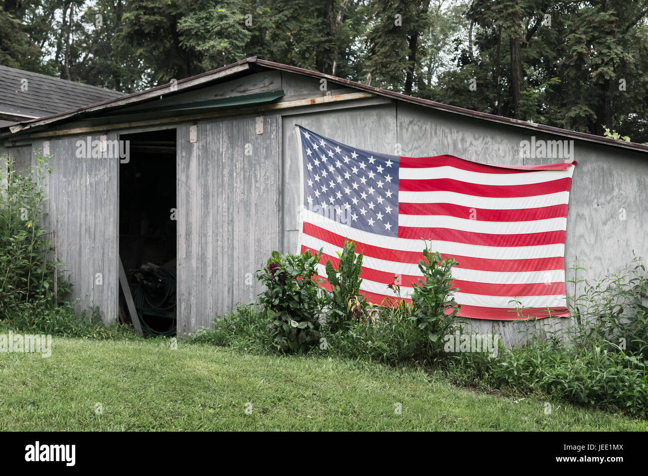 Old American flag on very rustic barn in western virginia Stock Photo