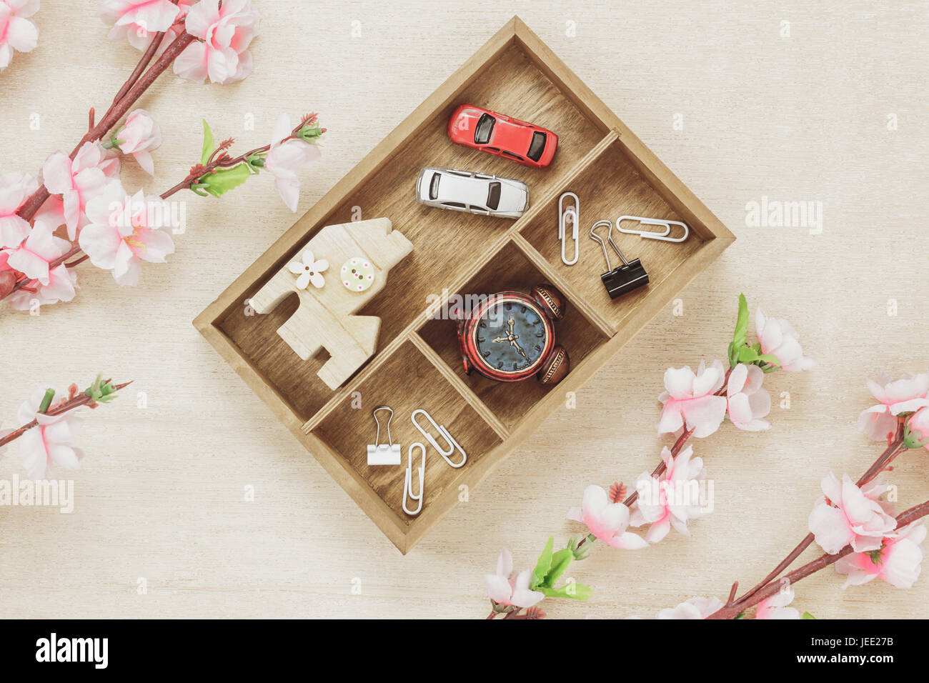 Top view business office desk concept. Wood house  also car and clock on wooden shelf.The beautiful pink flower on wood background with copy space. Stock Photo