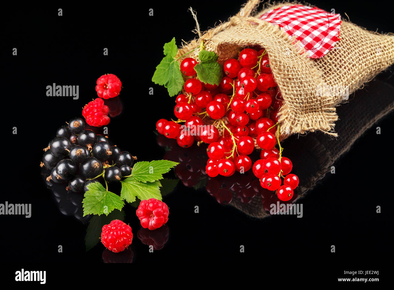 Fruits of raspberry, black currant and red currant on a dark background. Close-up Stock Photo